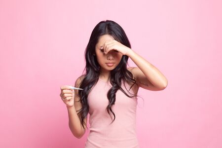 Young Asian woman got sick and flu on pink backgroundの写真素材