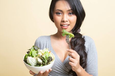 Healthy Asian woman with salad   on beige backgroundの写真素材