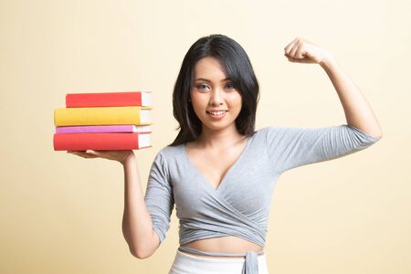 Young Asian woman studying  with may books   on beige backgroundの写真素材