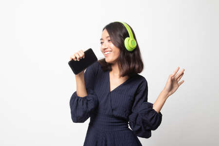 Pretty asian girl listening music with her headphones on white background