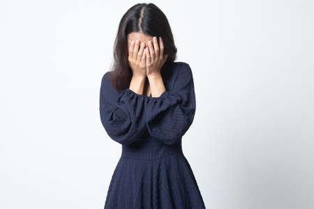 Sad young Asian woman cry with palm to face on white backgroundの写真素材