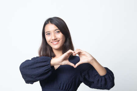 Young Asian woman show heart hand sign on white backgroundの写真素材