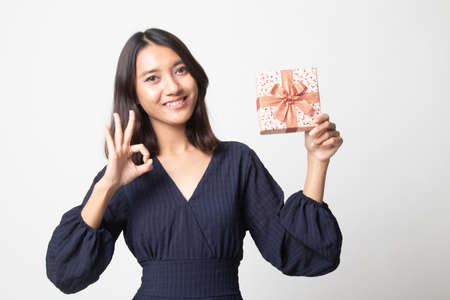 Young Asian woman show OK with a gift box on white backgroundの写真素材