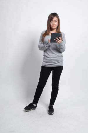 Young Asian woman with a computer tablet on white backgroundの写真素材