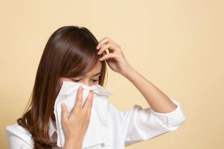 Young Asian woman got sick and flu on beige backgroundの写真素材
