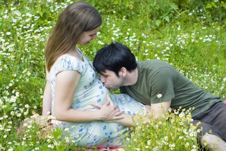 Husband with pregnant wife is resting in nature.の写真素材