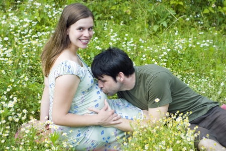 Husband with pregnant wife is resting in nature.の写真素材