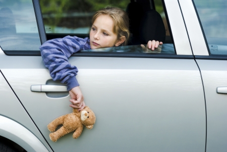 Little girl in car is going to miss her friends の写真素材