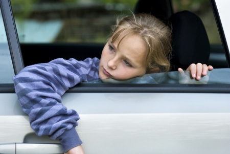 Little girl in car is going to miss her friends の写真素材