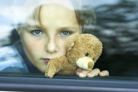 Little girl in car is going to miss her friends の写真素材