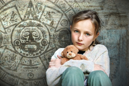 Frightened child with mayan calendar on her background.の写真素材
