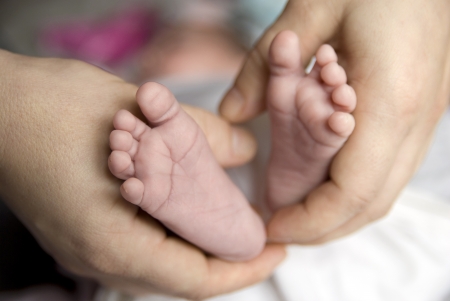 Mother is holding newborn feet.の写真素材