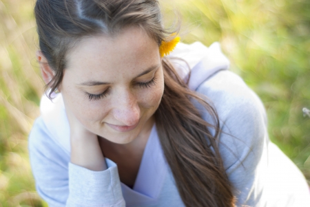 Girl with flower is enjoying sunshine.の写真素材