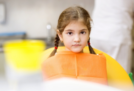 Little girl is having her teeth checked by dentistの写真素材