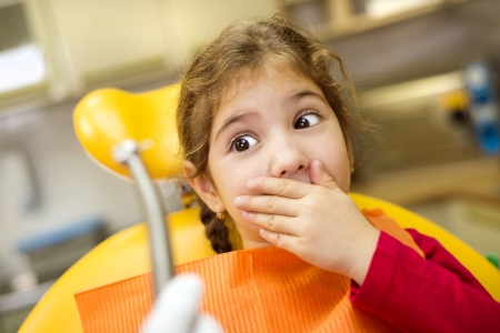 Little girl is having her teeth checked by dentistの写真素材