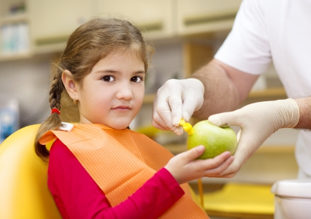 Dentist is showing the technique of teeth cleaning to a little girlの写真素材