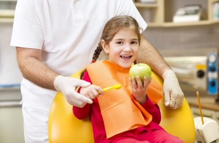 Dentist is showing the technique of teeth cleaning to a little girlの写真素材