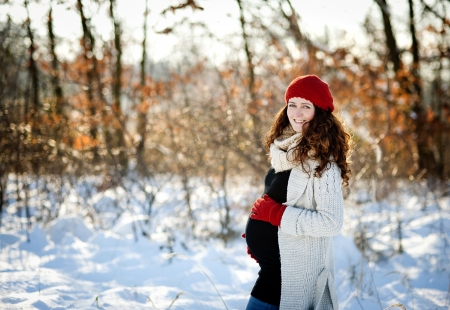A beautiful outdoor pregnant woman portrait in snowy natureの写真素材