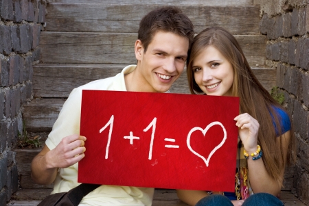 Young couple is holding board with romantic symbol.の写真素材