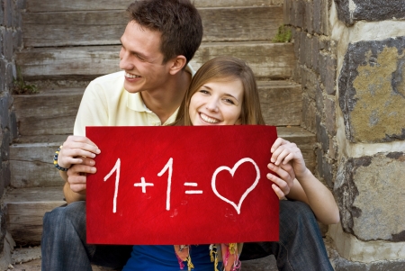 Young couple is holding board with romantic symbol.の写真素材