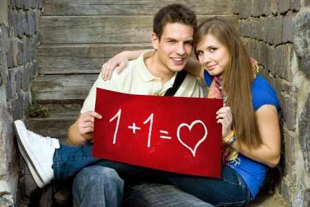 Young couple is holding board with romantic symbol.の写真素材