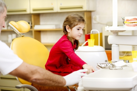 Little girl is having her teeth checked by dentistの写真素材