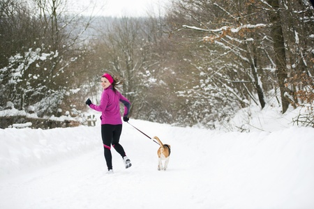 Athlete woman is running during winter training outside in cold snow weather.の写真素材