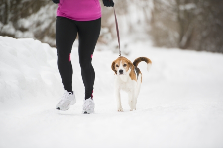 Athlete woman is running during winter training outside in cold snow weather.の写真素材