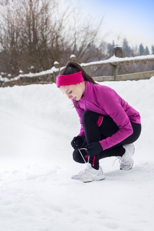 Athlete woman is running during winter training outside in cold snow weather.の写真素材