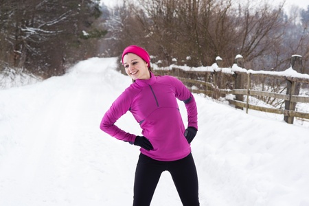 Athlete woman is running during winter training outside in cold snow weather.の写真素材