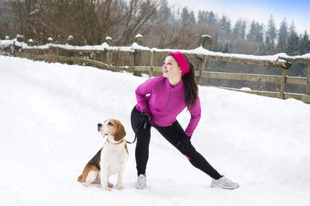 Athlete woman is running during winter training outside in cold snow weather.の写真素材