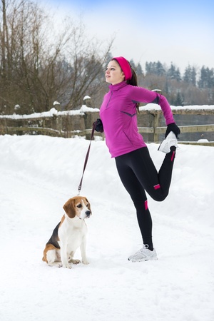 Athlete woman is running during winter training outside in cold snow weather.の写真素材