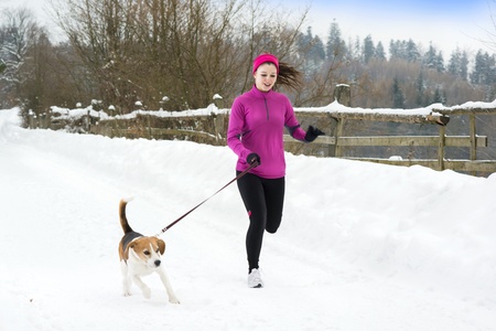 Athlete woman is running during winter training outside in cold snow weather.の写真素材