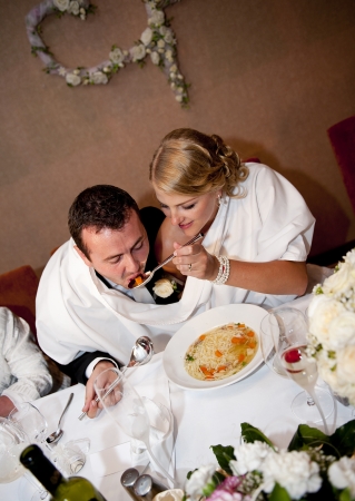 Bride and groom are eating at the wedding receptionの写真素材