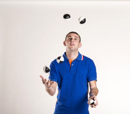 Young man juggling with several balls at onceの写真素材