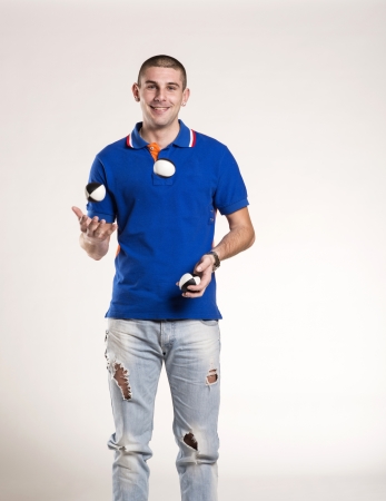 Young man juggling with several balls at onceの写真素材