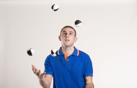 Young man juggling with several balls at onceの写真素材