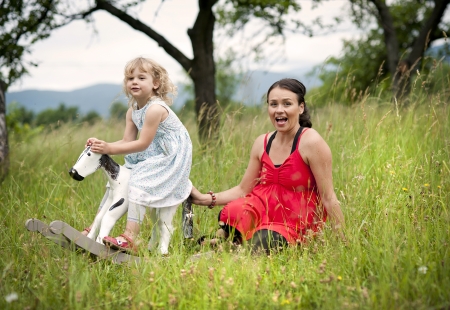 Happy family is playing together in a green meadow.の写真素材
