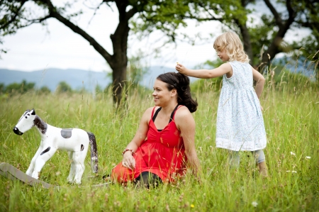 Happy family is playing together in a green meadow.の写真素材