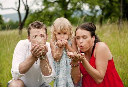 Happy family is playing together in a green meadow.の写真素材