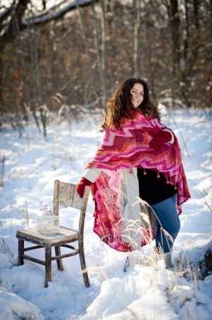 A beautiful pregnant woman is playing outside in the snowの写真素材
