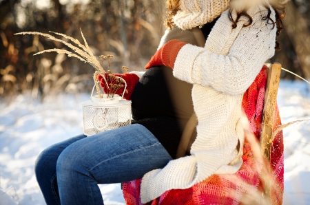 A beautiful outdoor pregnant woman portrait in snowy natureの写真素材