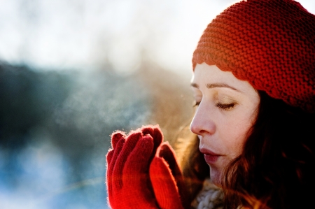 A beautiful pregnant woman is playing outside in the snowの写真素材