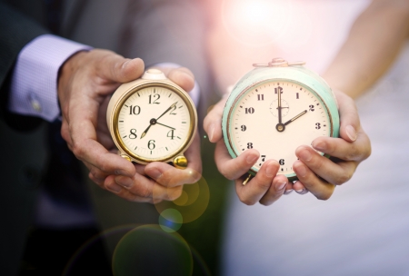Wedding couple is holding clocks