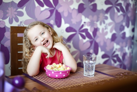 Little girl is eating snack in the kitchen の写真素材