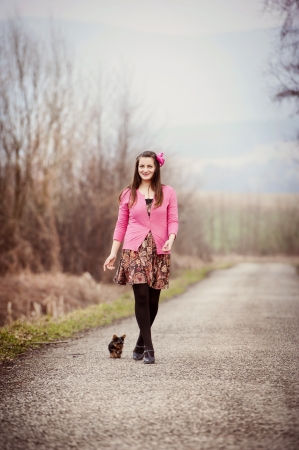 Young woman is outside with her yorkshire puppyの写真素材