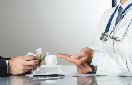 Closeup on medical doctor hands, taking moneyの写真素材