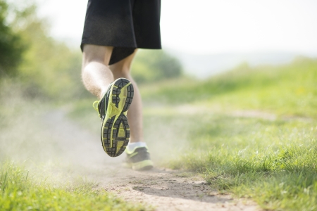 Young man is running in sunny natureの写真素材