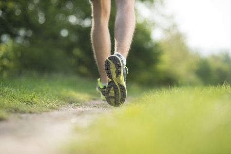 Young man is running in sunny natureの写真素材