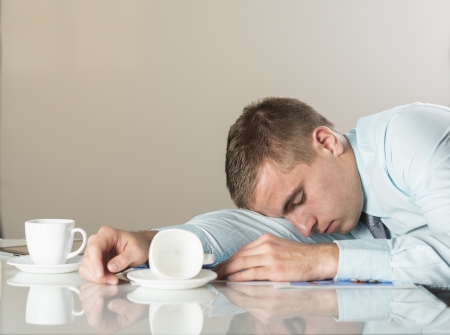 Tired businessman is sleeping in his officeの写真素材